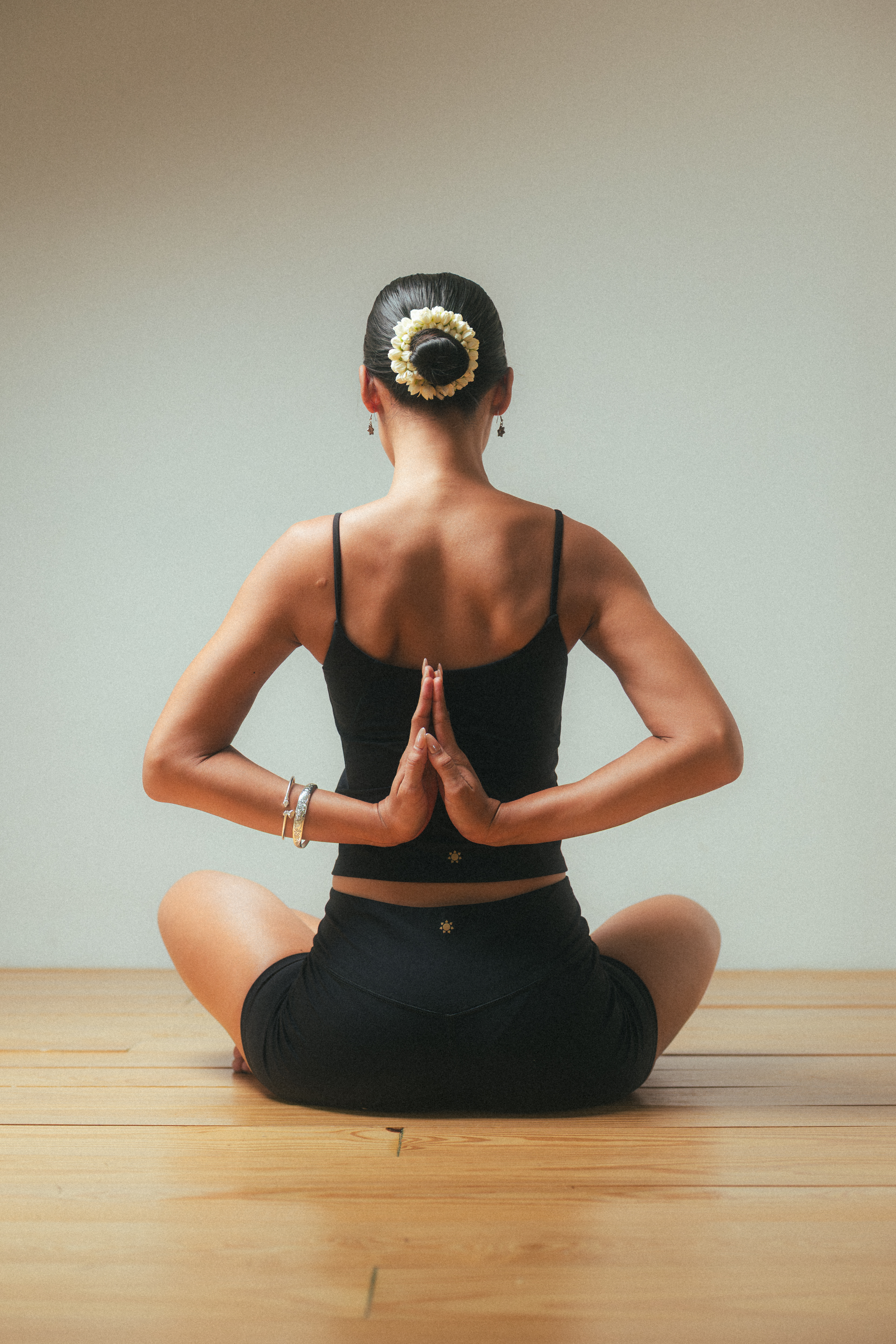 Woman in a reverse prayer yoga pose, viewed from behind